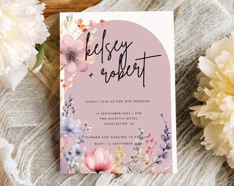 May include: Wedding invitation with a watercolor floral design in shades of pink, purple, and blue. The invitation features the names "Kelsey + Robert" and details for the wedding ceremony and reception.