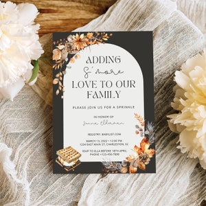 May include: A black and white invitation with a watercolour illustration of autumn leaves and a s'more. The text reads "Adding s'more love to our family. Please join us for a sprinkle in honour of Jenna Eldanan. Registry: Babylist.com. March 13, 2022 - 12:00 PM. 1234 East Main St, Charleston, SC. RSVP to Ella before 18th April. Phone +123-456-7890."