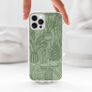 May include: A white phone case with a green outline design of potted plants. The phone case has a camera lens cutout.