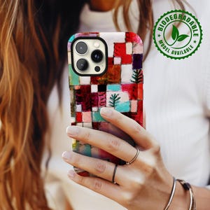 May include: A colorful phone case with a geometric pattern and a camera lens cutout. The case is made of biodegradable material and is available in different models. The text "Biodegradable Model Available" is printed on a green circle sticker.