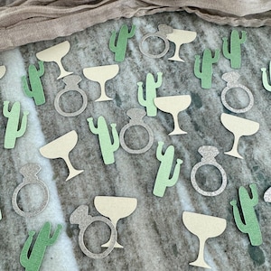May include: Green and silver confetti featuring cactus, margarita glasses, and rings. The confetti is perfect for a bachelorette party or bridal shower.