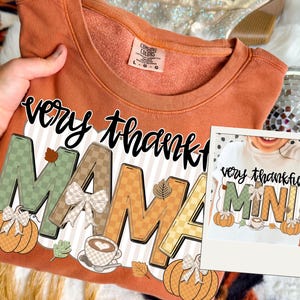 以下が含まれることがあります： オレンジ色のComfort Colorsのスウェットシャツ。秋をテーマにしたデザインで「very thankful MAMA」の文字がプリントされています。デザインにはカボチャ、葉、コーヒーカップが含まれています。小さな画像には「MINI」のお揃いのシャツが表示されています。