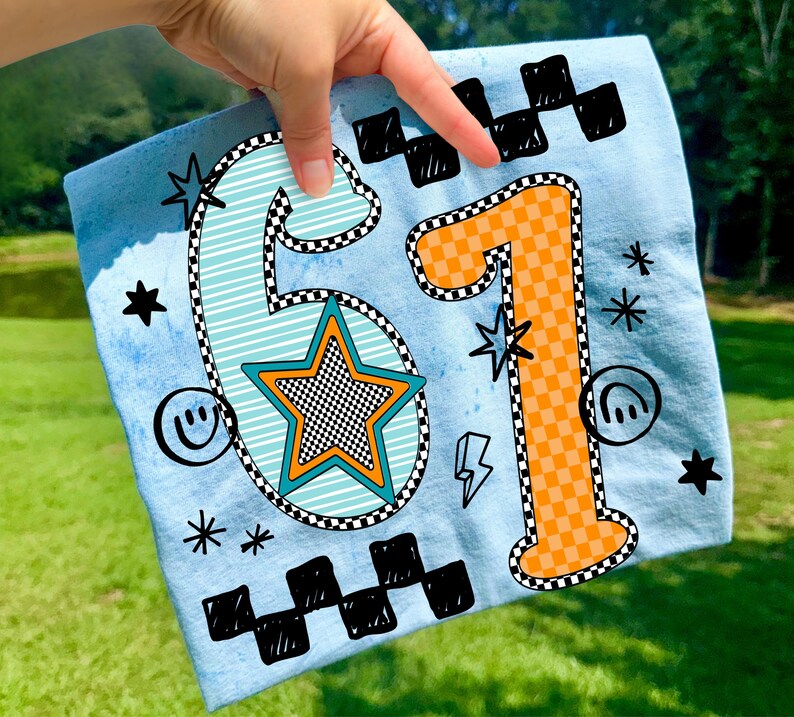 May include: Light blue fabric featuring the numbers 61 in a retro design. The number 6 is light blue with a checkered outline and a star in the center. The number 1 is orange with a checkered pattern. Additional graphics include stars, lightning bolts, and smiley faces.