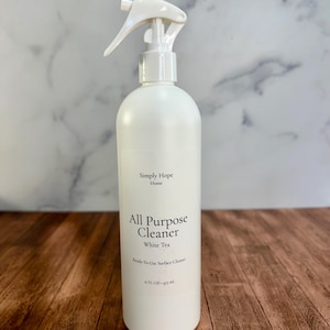 May include: A white plastic spray bottle of Simply Hope Home All Purpose Cleaner in White Tea scent. The label displays the text Simply Hope Home, All Purpose Cleaner, White Tea, Ready-To-Use Surface Cleaner, and 16 FL OZ 473 ml.