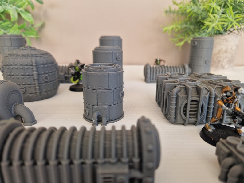 May include: A collection of gray, 3D printed, steampunk-style pipes and tanks. The pipes are made of a smooth, gray plastic and have a variety of shapes and sizes. The tanks are also made of a smooth, gray plastic and have a variety of shapes and sizes.