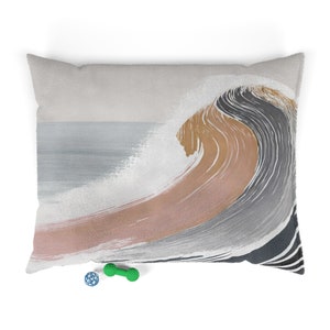 Può includere: Un cuscino decorativo con una pittura astratta stilizzata di un'onda in tonalità di grigio, marrone e rosa.
