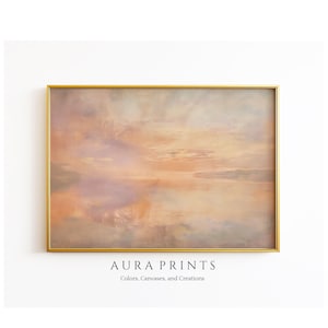 Può includere: Un dipinto astratto incorniciato con una tavolozza di colori tenui e smorzati di rosa, arancio e giallo. Il dipinto rappresenta un paesaggio nebbioso e sognante con un riflesso del cielo nell'acqua.
