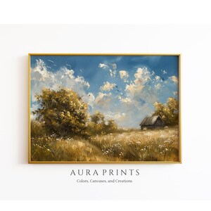 May include: A framed landscape painting with a gold frame. The artwork depicts a field of tall grass and wildflowers under a blue sky filled with fluffy white clouds. A small wooden structure is visible in the distance. The text "AURA PRINTS" is at the bottom.