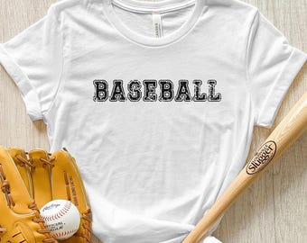 May include: White t-shirt with the word "BASEBALL" printed in black block letters. The shirt is shown with a baseball glove and a baseball bat.