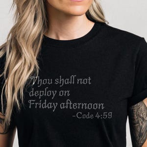 Könnte beinhalten: Schwarzes T-Shirt mit einem weißen Grafikdruck, auf dem "Thou shall not deploy on Friday afternoon -Code 4:59" steht.