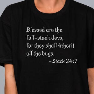 Peut inclure: T-shirt noir avec un graphique de texte blanc qui dit "Blessed are the full-stack devs, for they shall inherit all the bugs. - Stack 24:7"