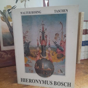 Peut inclure: Une couverture de livre avec une peinture d'un paysage fantastique de Jérôme Bosch. Le livre est intitulé "Jérôme Bosch" et est publié par Taschen. L'auteur est Walter Bosing.