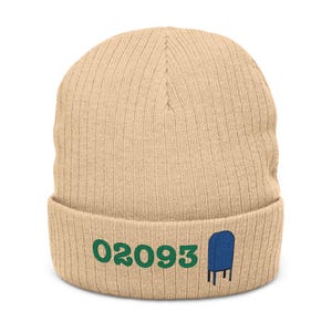 Peut inclure: Bonnet en tricot côtelé beige avec le numéro "02093" brodé en vert et un motif de boîte aux lettres bleu. Un accessoire chaud et décontracté.