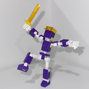 May include: A purple and white articulated action figure holding a gold sword. The figure has a gold helmet and is posed in a dynamic action pose.