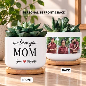 May include: Two white ceramic planters with bamboo saucers, each containing a green succulent. The front planter features the black text "we love you MOM" and "Gina ❤️ Maddie". The back planter displays three printed color photographs of people.