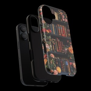 Puede incluir: Una funda de tel&eacute;fono negra con un dise&ntilde;o floral que presenta una estanter&iacute;a llena de libros. La funda tiene una protuberancia de c&aacute;mara elevada y un recorte para los botones del tel&eacute;fono.