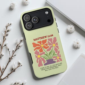 May include: A light green phone case featuring a floral design with orange and pink flowers in a purple vase. The text "MATTHEW 11:28" is above the flowers, and the quote "COME TO ME, ALL YOU WHO ARE WEARY AND BURDENED, AND I WILL GIVE YOU REST" is below.