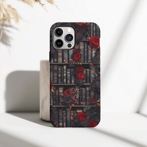 May include: A black phone case with a design of a bookshelf filled with books and red roses.