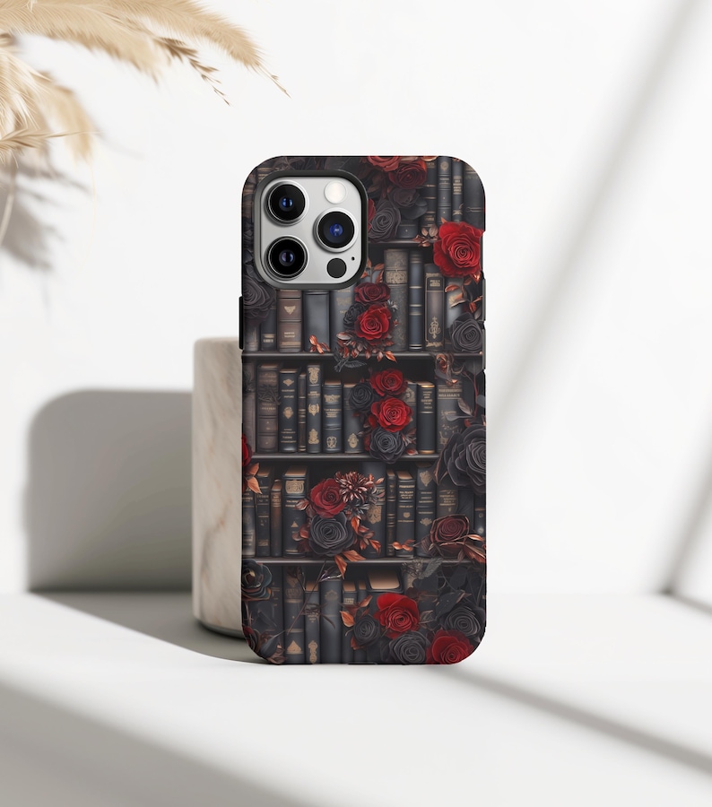 May include: A black phone case with a design of a bookshelf filled with books and red roses.