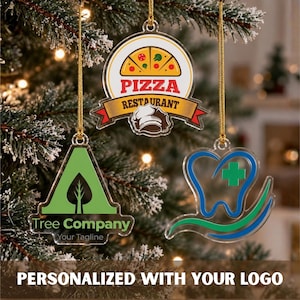May include: Three clear acrylic ornaments hanging by gold strings. The top ornament features a pizza graphic with the text PIZZA RESTAURANT. The bottom left shows a green triangle with a tree and the text Tree Company. The bottom right shows a blue tooth icon with a green cross.