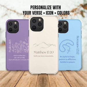 May include: Three phone cases in lavender, cream, and light blue, each with a unique design. The lavender case features floral line art and text from Psalm 46:5. The cream case has mountain line art and Matthew 17:20. The blue case displays a rosary and Romans 12:12.