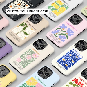 May include: A collection of phone cases with floral designs and scripture verses. The cases feature various colors, including pink, purple, yellow, and blue. The text "CUSTOM YOUR PHONE CASE" is visible on one case.