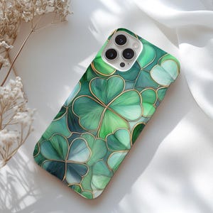 May include: A green and gold phone case with a four-leaf clover pattern.