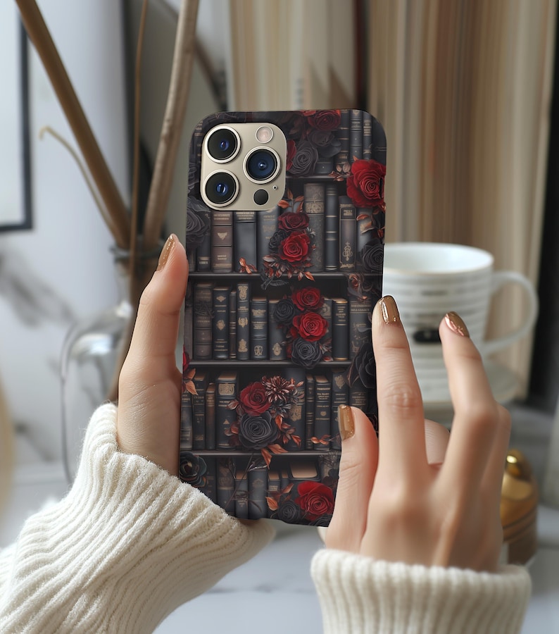May include: A black phone case with a design of a bookshelf filled with books and red roses.