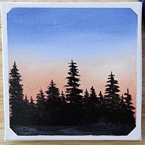 Puede incluir: Pequeña pintura cuadrada que representa un paisaje sereno. El cielo transiciona de azul claro a melocotón. Siluetas oscuras de árboles de hoja perenne forman una línea en la parte inferior, creando una sensación de profundidad.