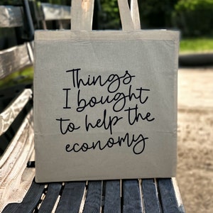 May include: A gray canvas tote bag with black text that reads "Things I bought to help the economy".