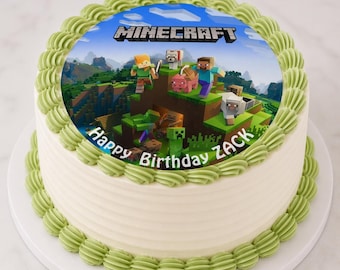 May include: A round cake with white frosting and green frosting trim. The top features a Minecraft-themed image with characters and the game's logo. The words "Happy Birthday Zack" are also on the cake.