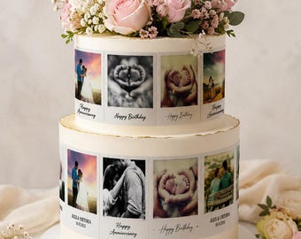 May include: Two-tiered white cake decorated with edible photo strips and topped with pink and white roses and greenery. The photo strips feature images and text that read "Happy Anniversary" and "Happy Birthday".