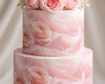 May include: A two-tier cake decorated with a soft pink fabric-like pattern featuring printed roses. The cake is topped with a cluster of fresh light pink roses. The base of each tier is accented with a thin gold trim, and the entire cake sits on a white circular stand.