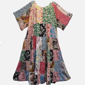 May include: A knee-length dress featuring a patchwork design composed of various fabric squares. The patterns include floral prints, botanical motifs, and geometric shapes in a vibrant color palette of pink, green, blue, yellow, and black.