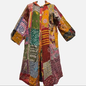 May include: A patchwork coat with a hood, featuring a variety of colorful fabric squares. The coat has long sleeves and pockets, with a button-up front. The colors include red, green, yellow, and blue, creating a vibrant and unique design.