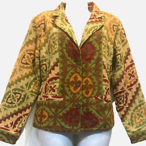 May include: A patterned blazer in shades of tan, green, and brown. The jacket features a geometric design with button closures and a collared neckline. The blazer has long sleeves and two front pockets.