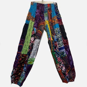 May include: Patchwork pants with a vibrant mix of colors and patterns, including blue, purple, green, and red. The pants have a relaxed fit and are made from various fabric patches. The waist is elasticized.