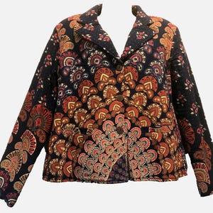May include: A quilted blazer with a dark navy background and a repeating pattern of orange, red, and white fan-like shapes. The blazer has a notched collar, two front pockets, and wooden buttons. The sleeves are long, and the overall style is vintage.