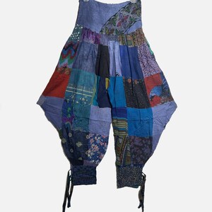 May include: Patchwork harem pants in shades of blue, red, and purple. The pants feature a variety of patterned fabric squares sewn together. The loose-fitting pants have a drawstring at the ankles.