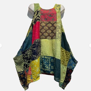 May include: A sleeveless patchwork dress in a variety of colors, including red, green, blue, and yellow. The dress has a unique, asymmetrical hemline and is made of different fabric squares sewn together.