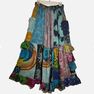 May include: A set of three ceramic mugs with a speckled, cream-colored glaze. Each mug features a different hand-painted floral design in shades of blue, green, and yellow. The mugs have a simple, modern shape with a comfortable handle.