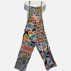 May include: A sleeveless jumpsuit featuring a patchwork design with various geometric, floral, and abstract patterns in shades of blue, orange, yellow, black, and white. The garment has wide legs, a square neckline, and thin shoulder straps.