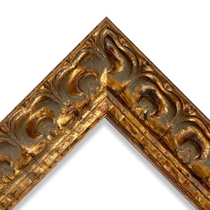 May include: Close-up of a corner of a gold-colored picture frame. The frame has ornate, carved details and a distressed finish, with hints of dark brown peeking through the gold. The frame is set against a white background.
