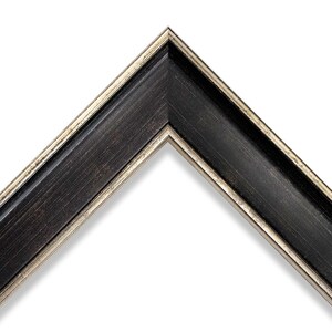 Può includere: Primo piano di un angolo di una cornice nera con un bordo interno dorato metallico. La cornice ha una finitura scura strutturata e un bordo smussato, creando un aspetto classico. La cornice è posta su uno sfondo bianco.
