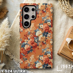 May include: A floral phone case for the Galaxy S24 Ultra. The case features a vintage floral pattern with orange, yellow, and blue flowers on a brown background.