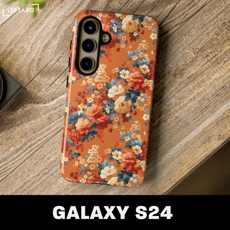 May include: A floral phone case for the Samsung Galaxy S24. The case features a vibrant orange background with a pattern of red, white, and blue flowers.
