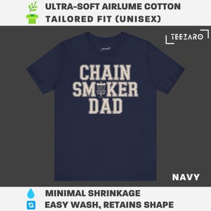 May include: Navy blue t-shirt with a white graphic that says "Chain Smoker Dad" with a disc golf disc in the middle of the word "Smoker".
