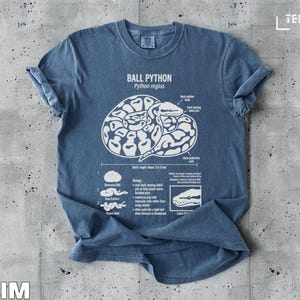 Ball python illustration on a denim t-shirt with text describing its biology and habitat.