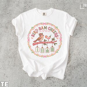 T-shirt with "Bird Bam Cheers" text and two birds toasting with cocktails.