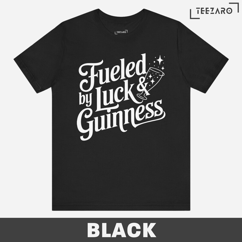 Puede incluir: Camiseta negra con texto blanco que dice "Fueled by Luck & Guinness" con un vaso de Guinness estilizado y estrellas.